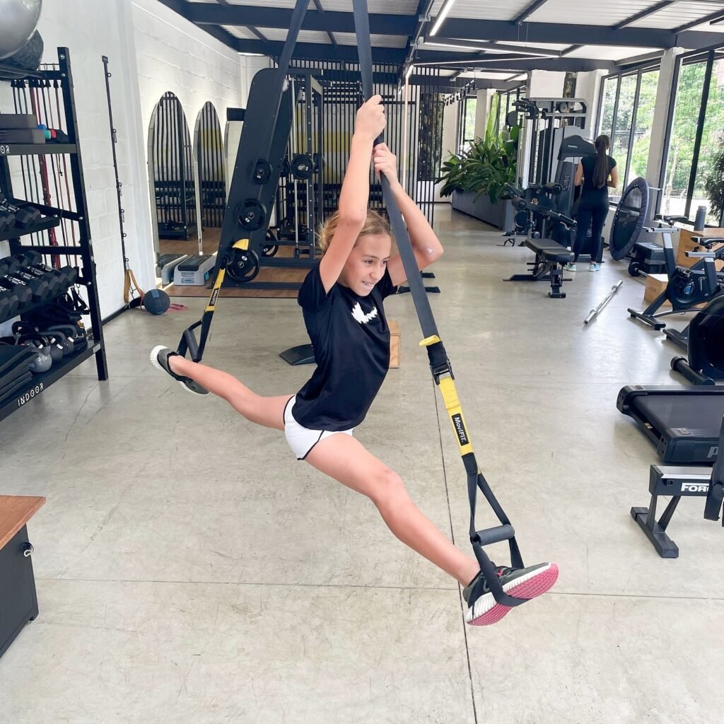 Niña entrenando con bandas de suspensión en la sede de BeStrong